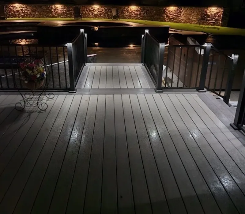 Composite deck photographed at night showing recessed under-rail and ceiling lighting
